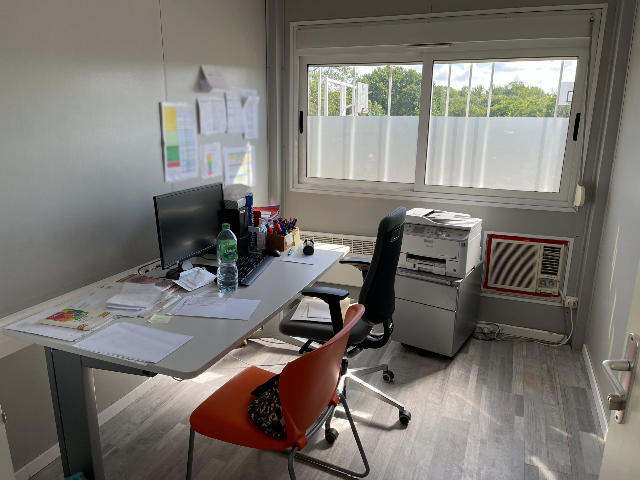 Bureau de l'infirmerie du DITEP l'Escale avec une fenêtre montrant un extérieur verdoyant