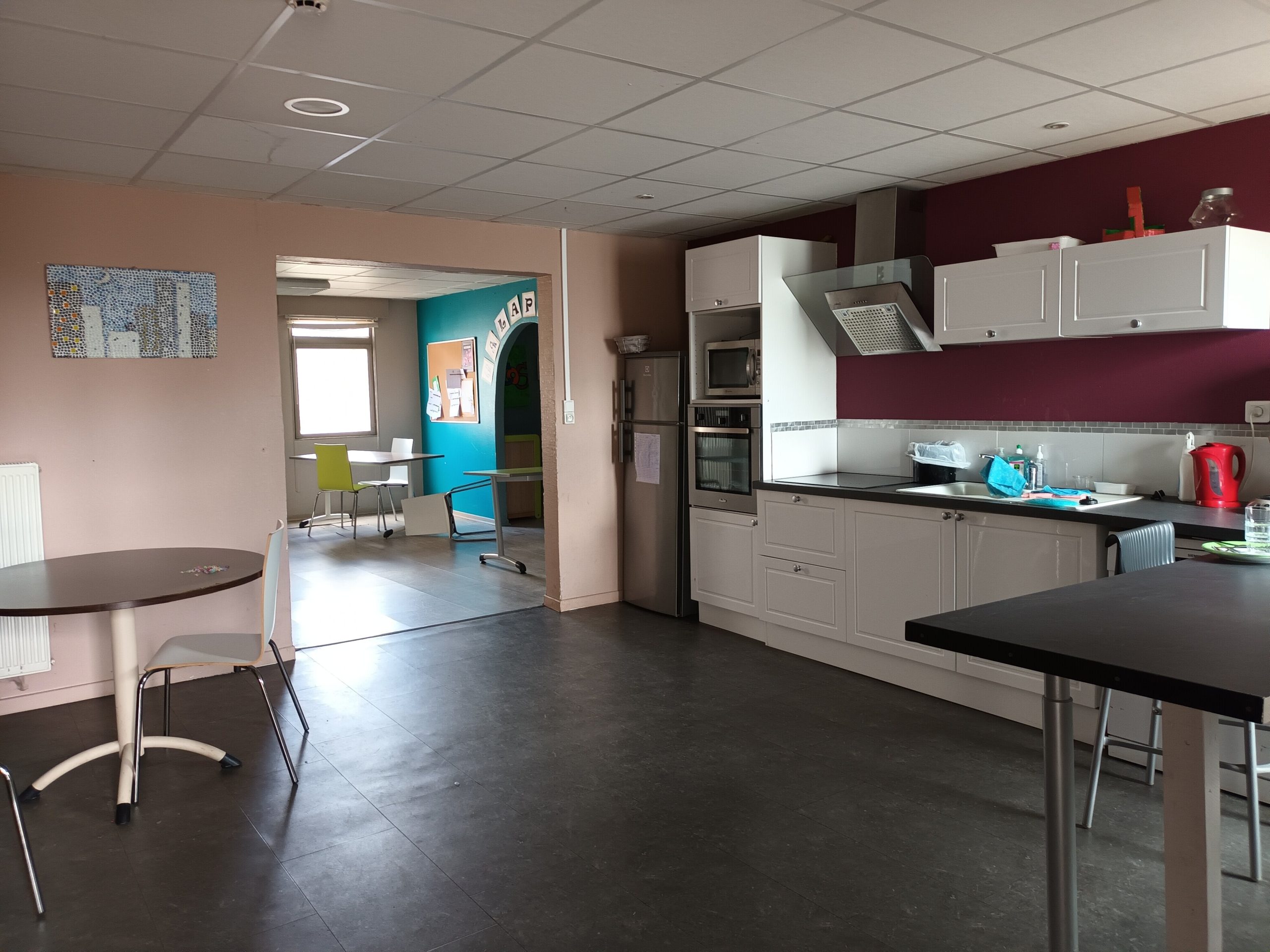 Salle de vie commune du DITEP l'Escale, montrant une cuisine tout équipée ouverte sur une salle a manger, et une autre salle de vie commune
