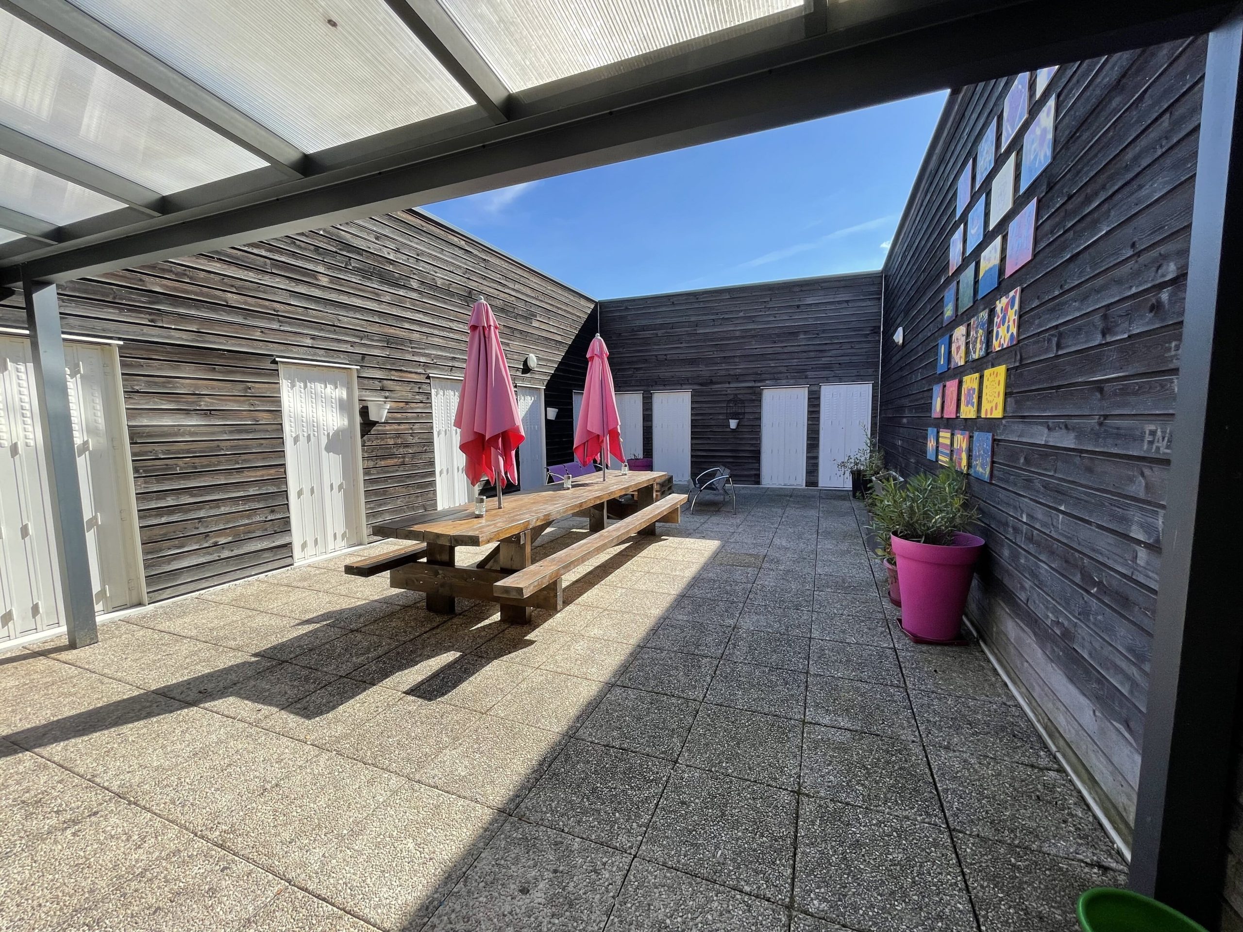 Cour extérieur, montrant une table et des bancs en bois,